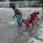 Young boy playing at a fountain park