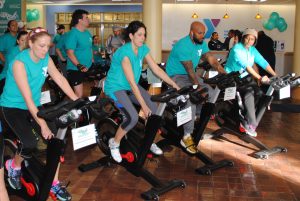 A group of people in green t-shirts cycling at the LIVESTRONG event in Central Massachusetts. 