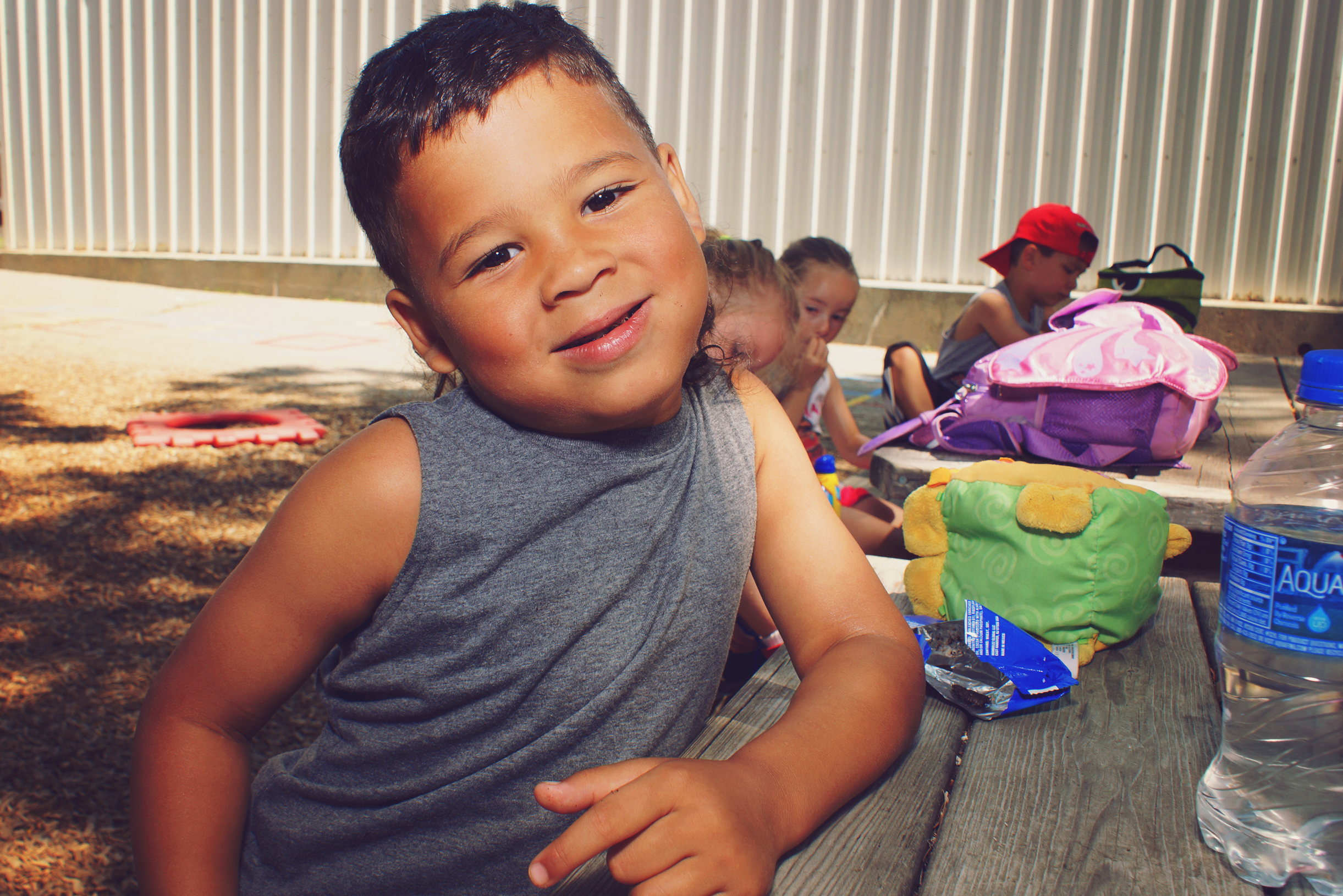 A young boy sitting at a picnic table posing for a picture