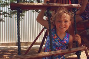 A smiling little girl at summer camp in Central Massachusetts, enjoying a sunny day outdoors.