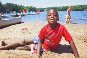 A Student is Posing at a Beach During their Sumap Camp near a Lake in Central Massachusetts.