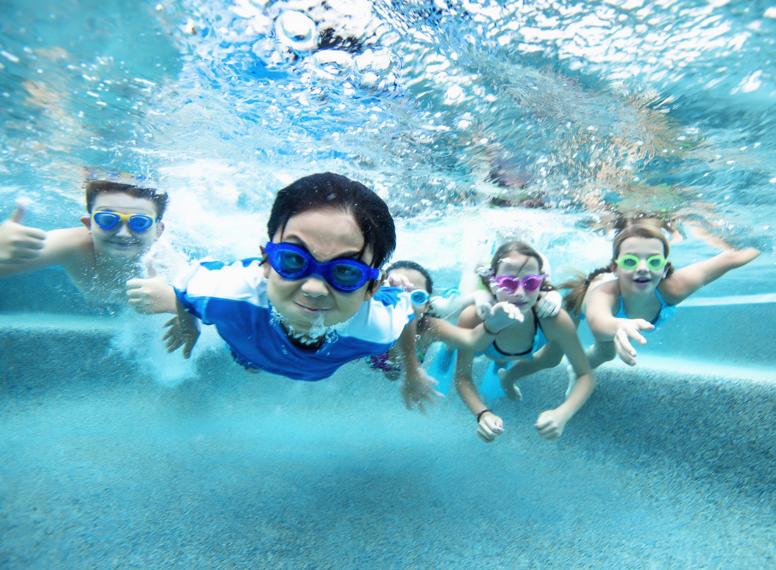 Group of young children swimming under water