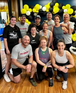 A group of people posing for a picture after a workout at a gym in Central Massachusetts