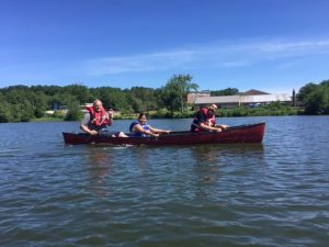 Three people are kayaking at a lake in Central Massachusetts