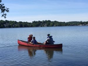 Three people kayaking at a summer camp event in Central Massachusetts
