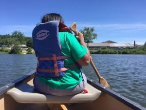 A woman kayaking at a summer camp event in Central Massachusetts