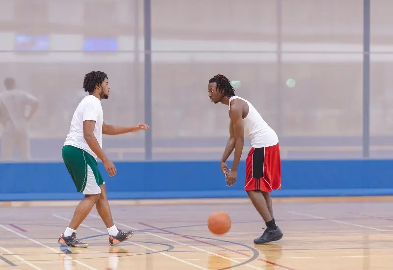 Teenagers playing basketball in gym