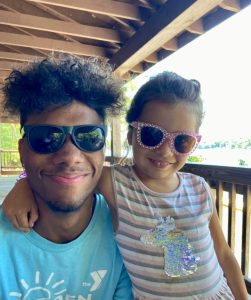 A Man and a little girl wearing sunglasses, enjoying a Summer Camp in Central Massachusetts.