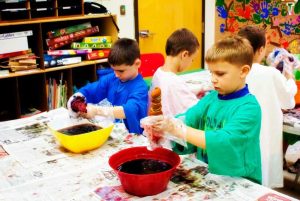 A group of children in a classroom engaged in painting activities in Central Massachusetts.