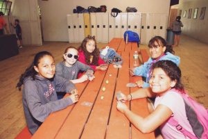 Girls enjoying time together at a picnic table at YMCA Camp Lowe in Central Massachusetts