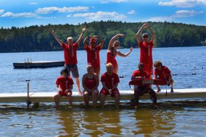 Group of people posing on a dock at YMCA Camp Lowe in Central Massachusetts