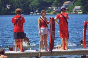 YMCA Camp Lowe lifeguards on dock by lake in Central Massachusetts