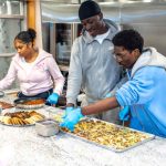 Group assembling food trays during the YMCA of Central Massachusetts activity