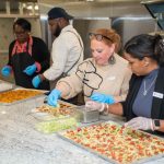 Team member preparing food trays in the YMCA of Central Massachusetts kitchen