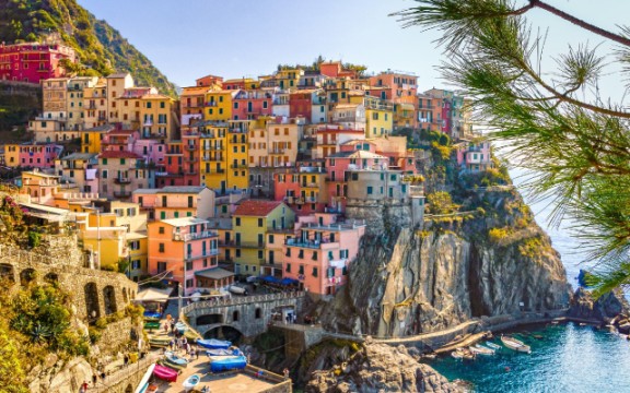Colorful coastal buildings of Manarola, Cinque Terre, Italy, perched on a rugged seaside cliff
