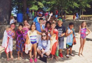 Group of kids wrapped in colorful towels posing together at YMCA Camp Lowe in Central Massachusetts