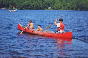 A Student in a Boat Enjoying the Best Summer Vacation at the YMCA in Central Massachusetts