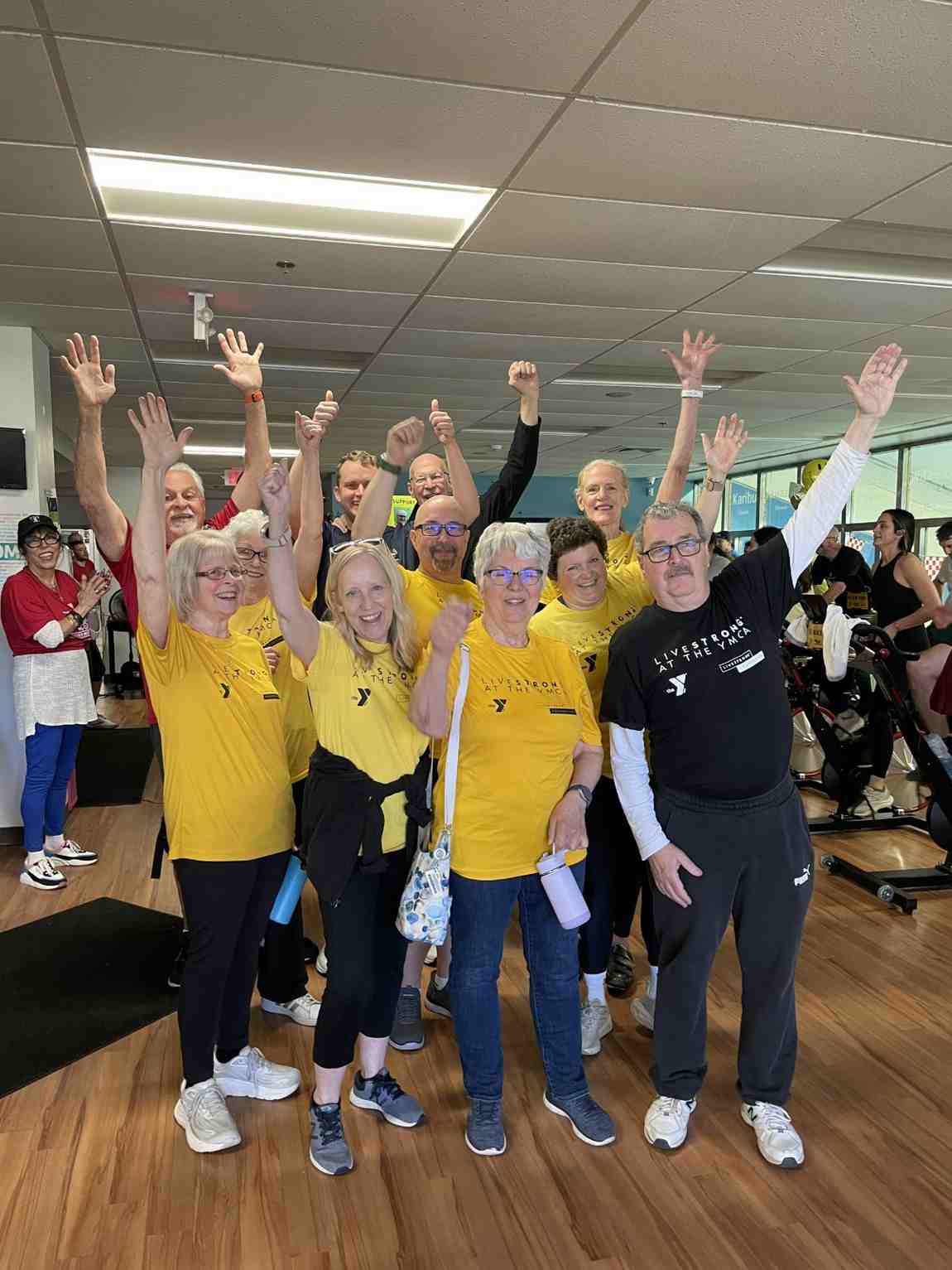 YMCA Mission in Motion group participants celebrate an indoor cycling fundraiser event