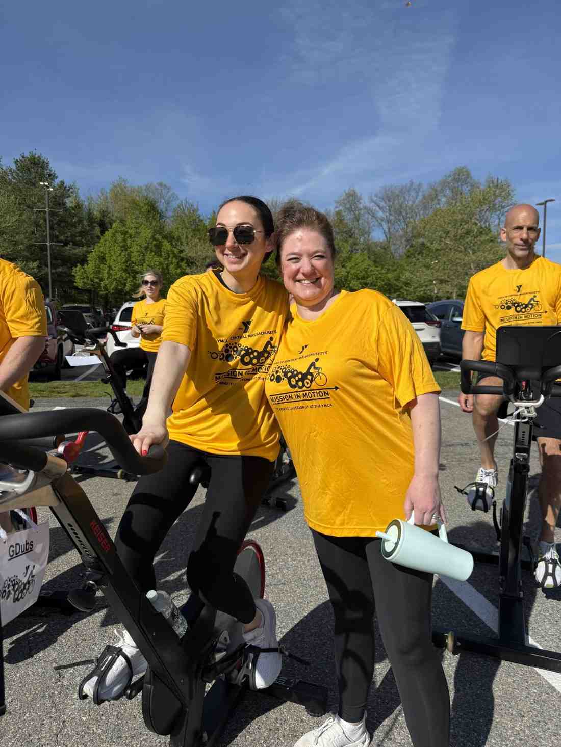 YMCA Mission in Motion event participants standing by stationary bikes during an outdoor fundraiser