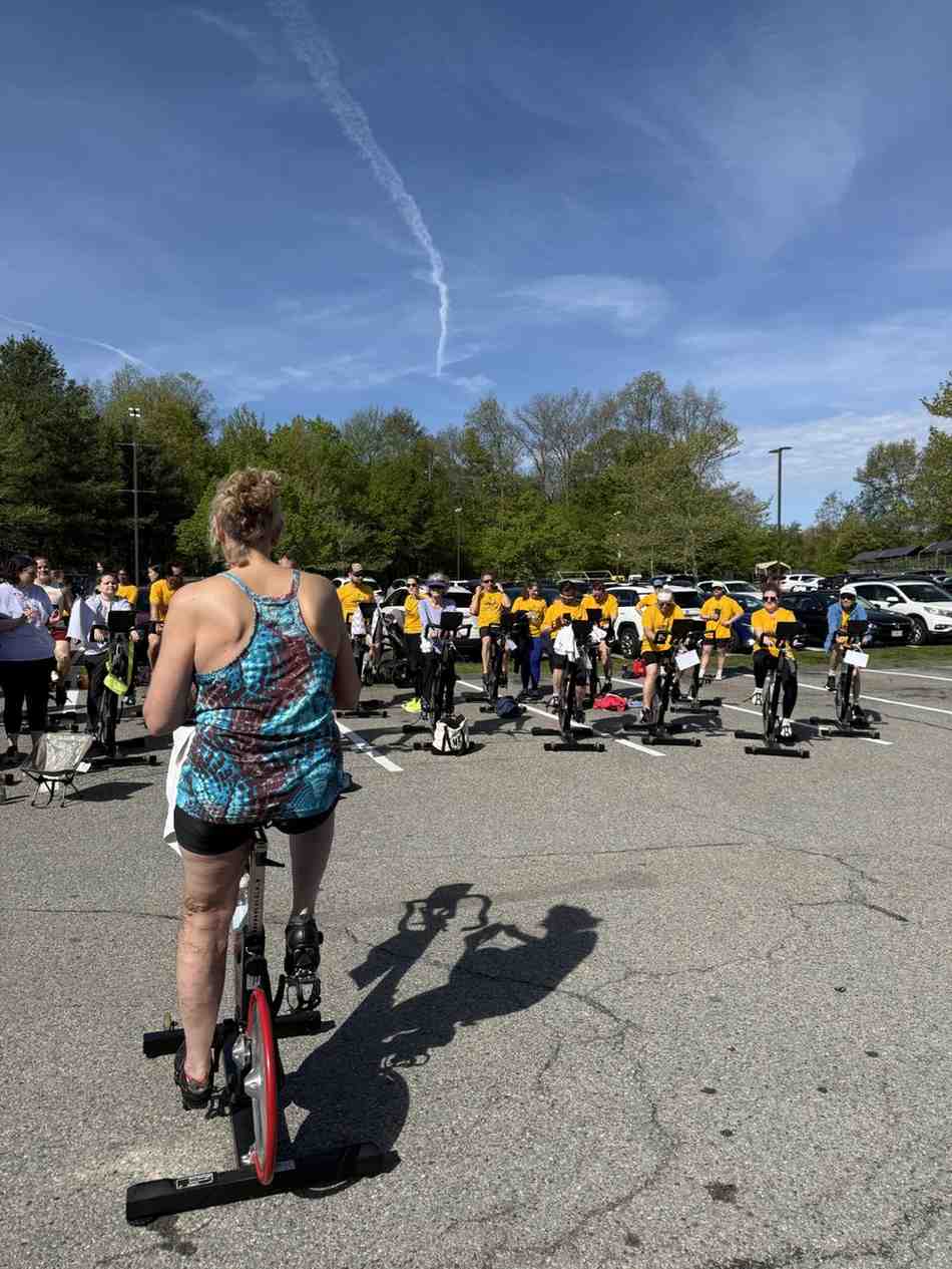 Group cycling event participants using stationary bikes outdoors at the YMCA Mission in Motion