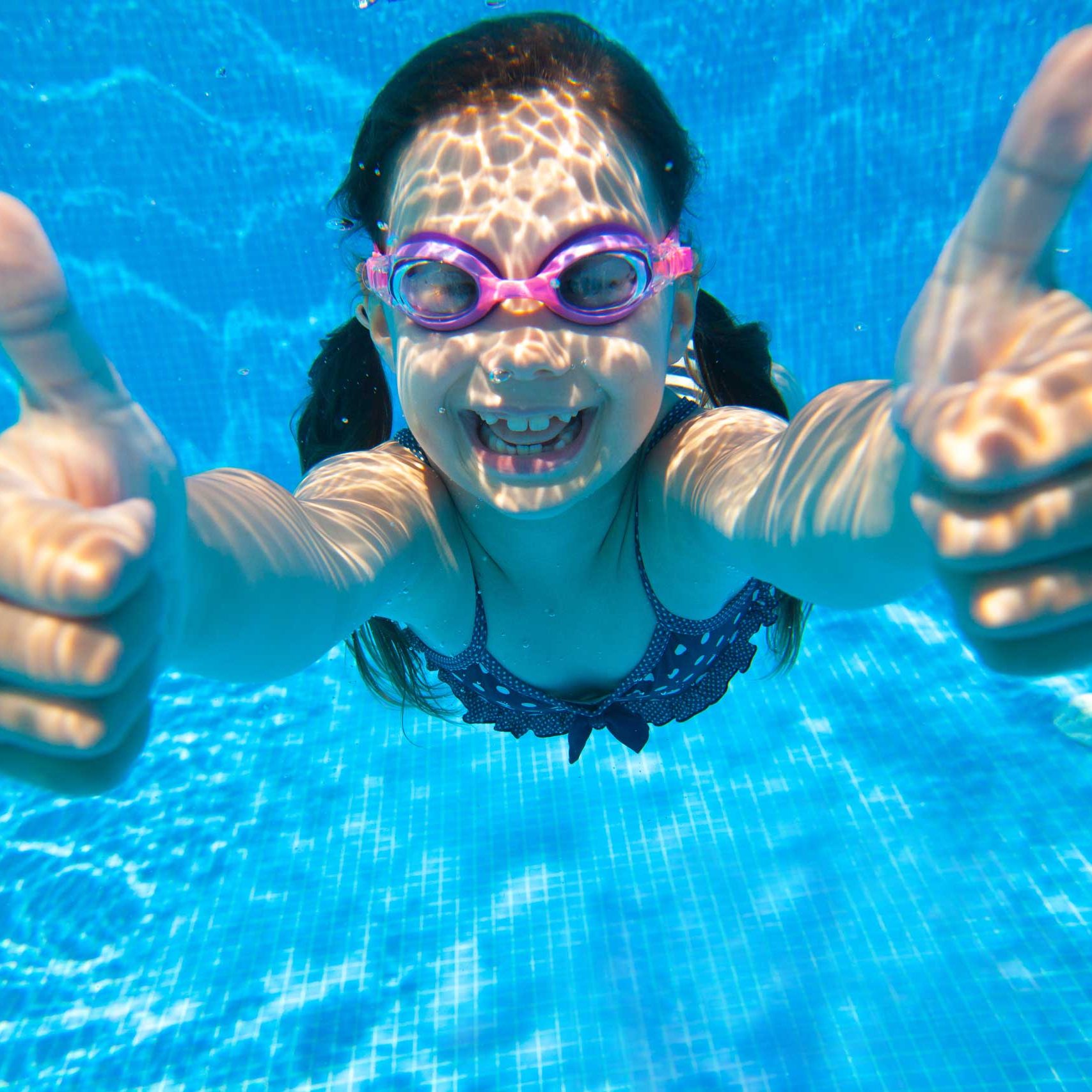 girl swimming with two thumbs up girl swimming with two thumbs up
