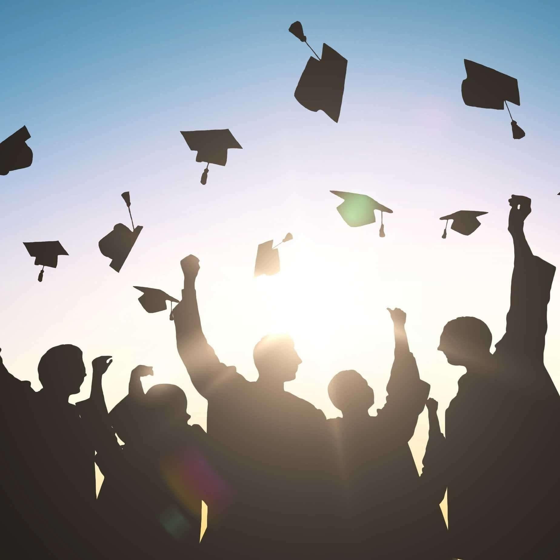 Graduates throwing caps after a graduation ceremony event in Central Massachusetts